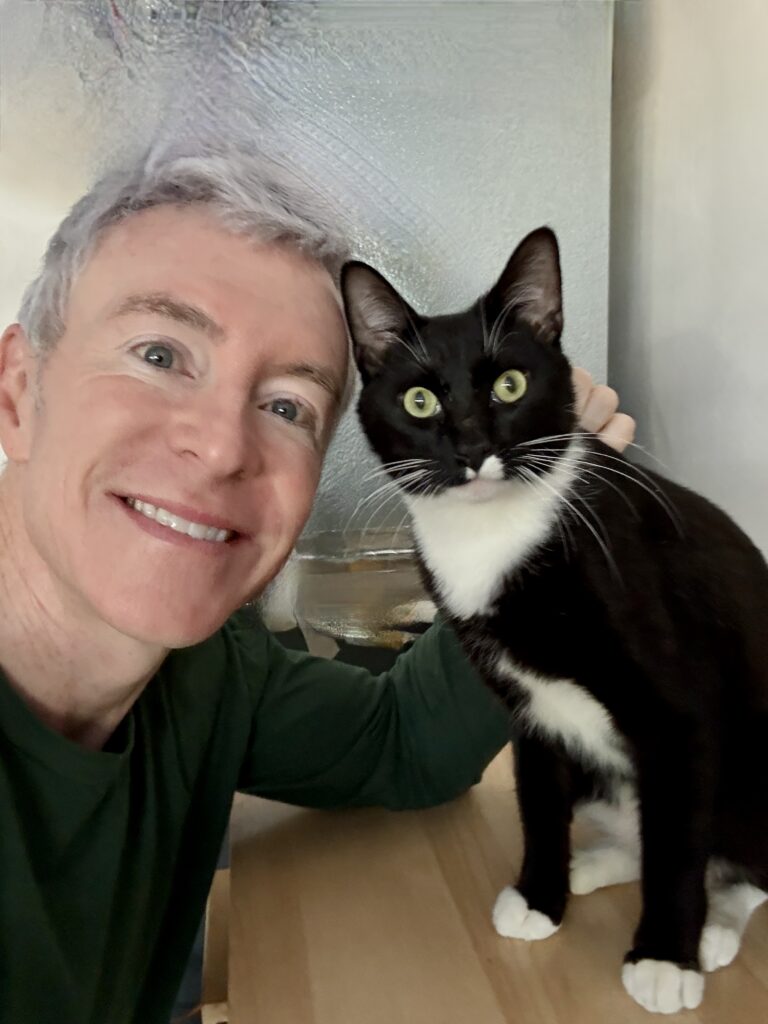 Man Holding a Black and White Cat Indoors