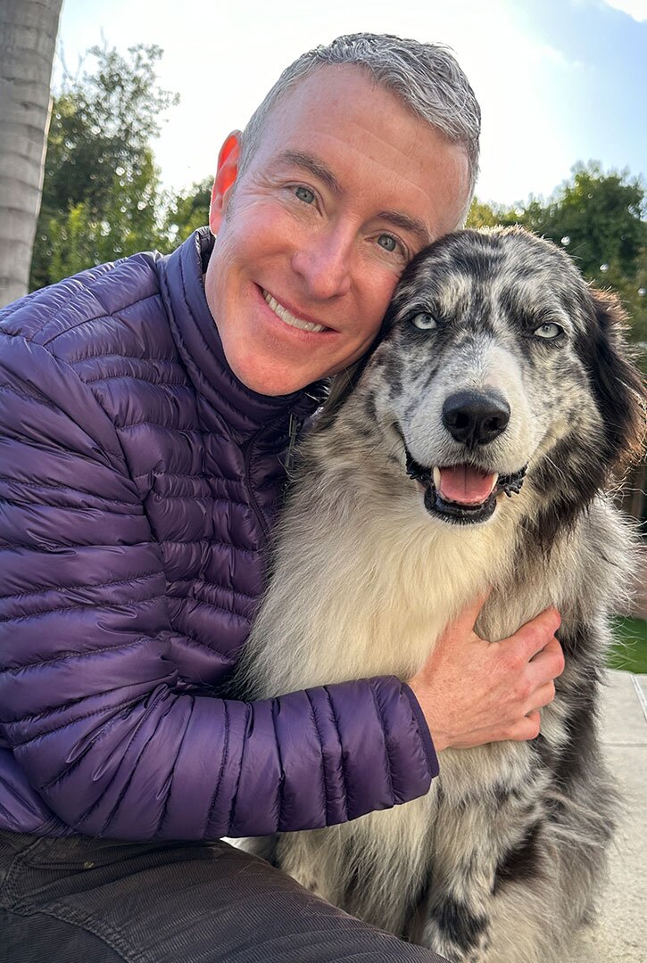 Michael R Burke hugging his dog