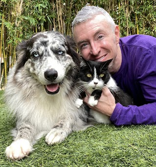 Michael R. Burke with a relaxed cat and dog outside