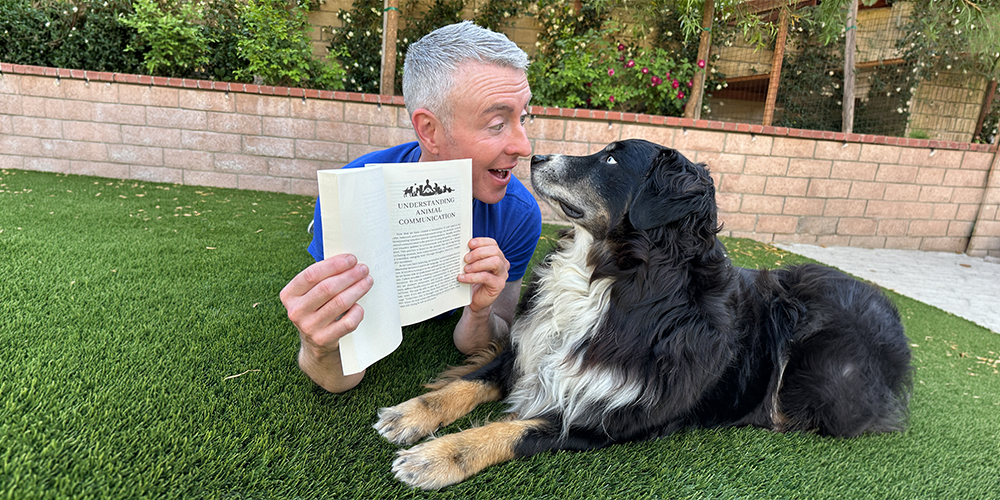 Michael Burke - animal communicator showing his book to his dog